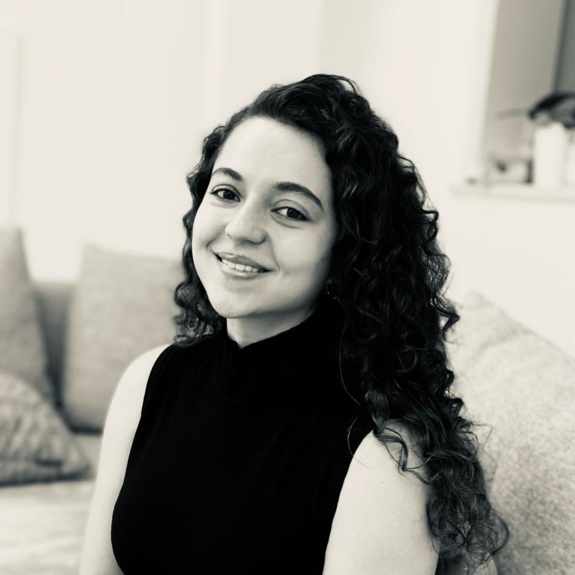 Image of a woman wearing a dark top smiling at the camera