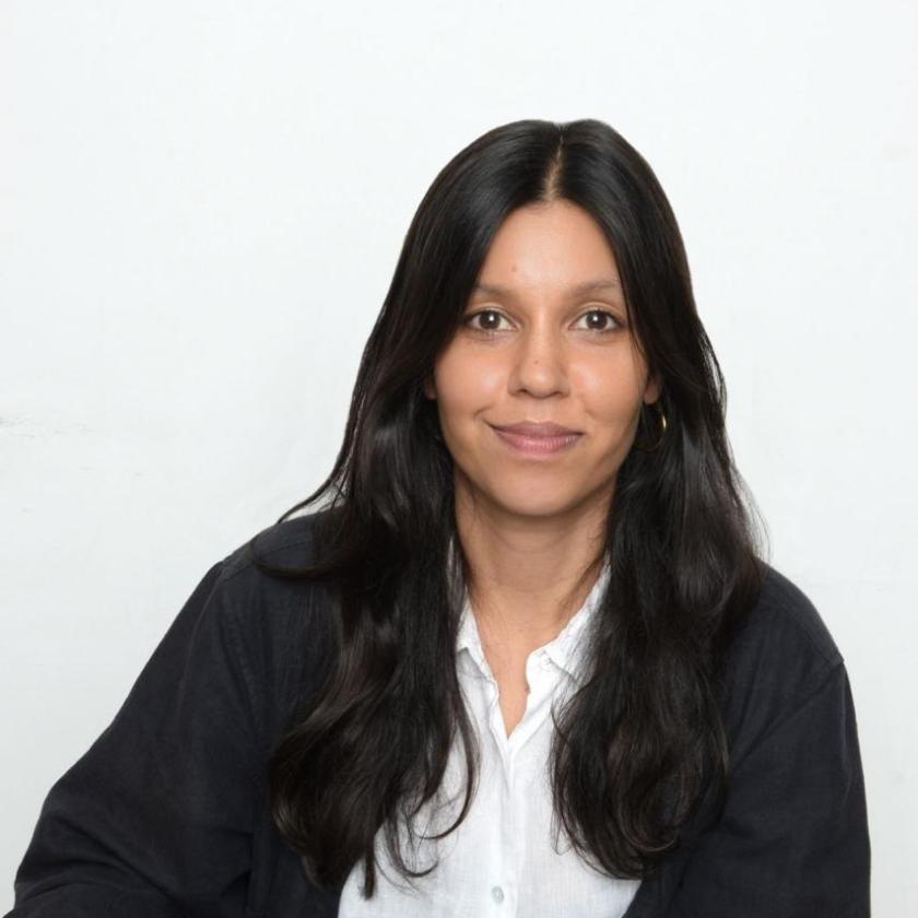 Image of a woman wearing a dark top and white shirt smiling at the camera