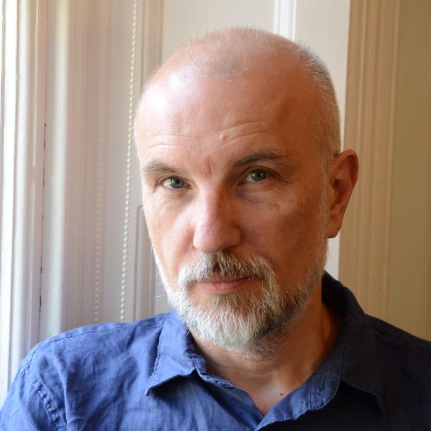 Image of a man wearing a blue shirt smiling at camera