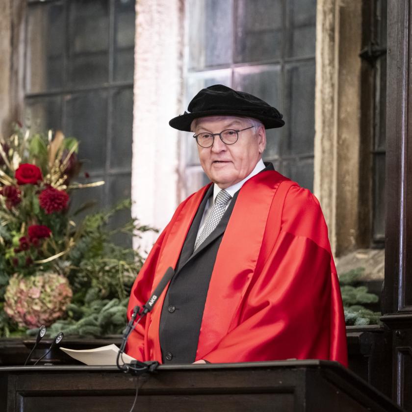 image of a man in academic ceremonial garb looking at the camera