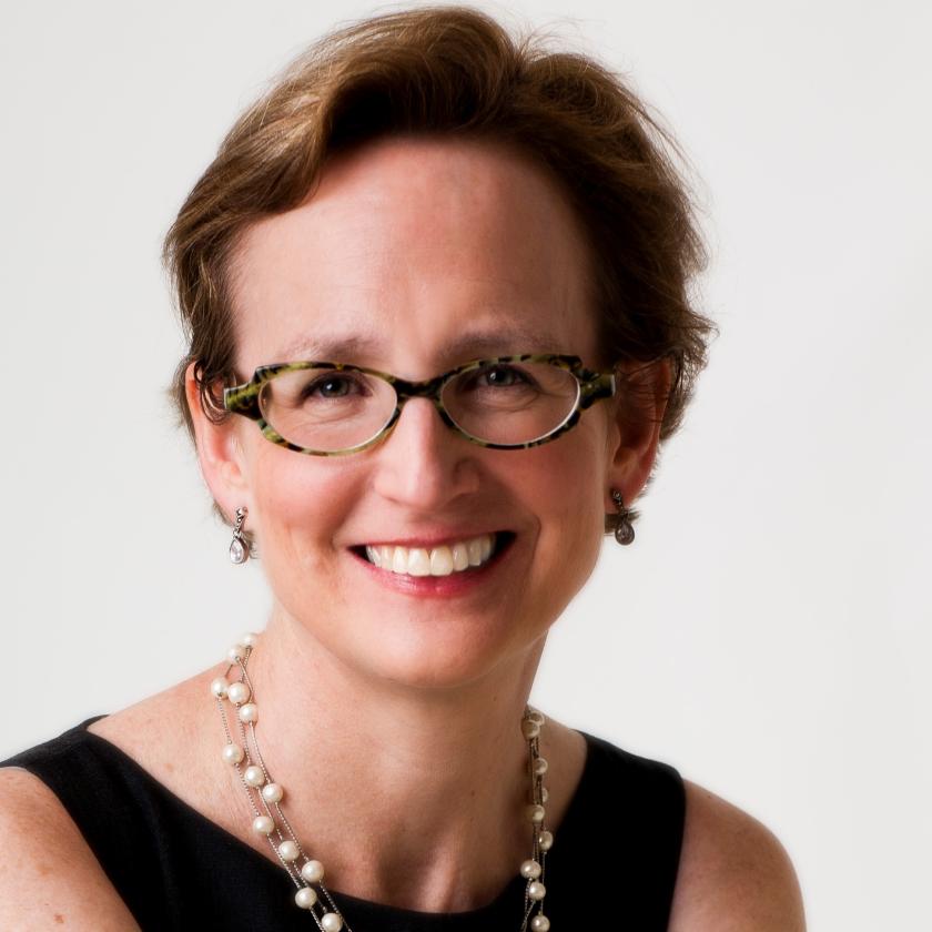 Image of a woman wearing glasses smiling at the camera