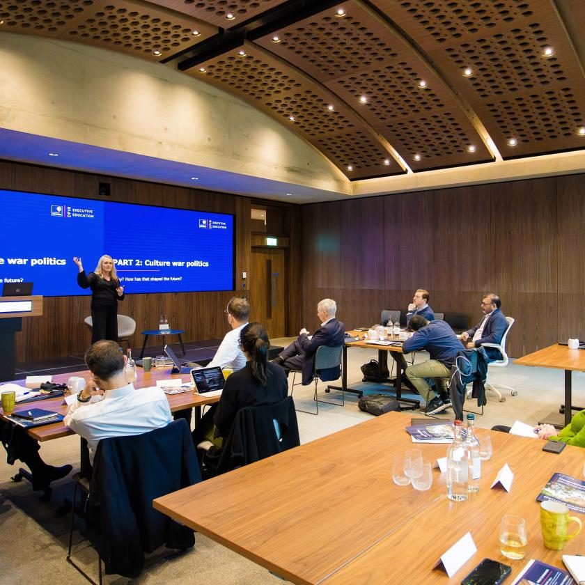 Image of people in a room looking at a presentation on a screen
