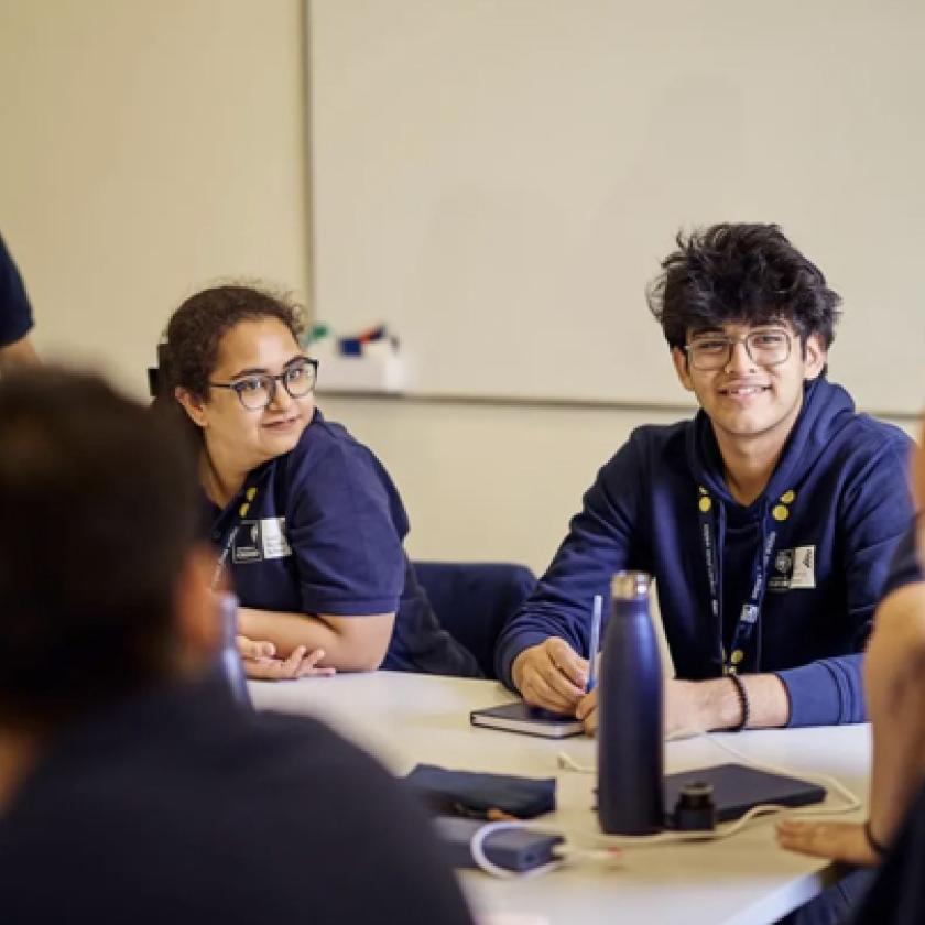 imge of five students, some seated at a table