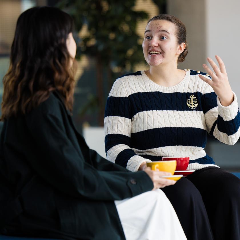 image of two students sat on a bench