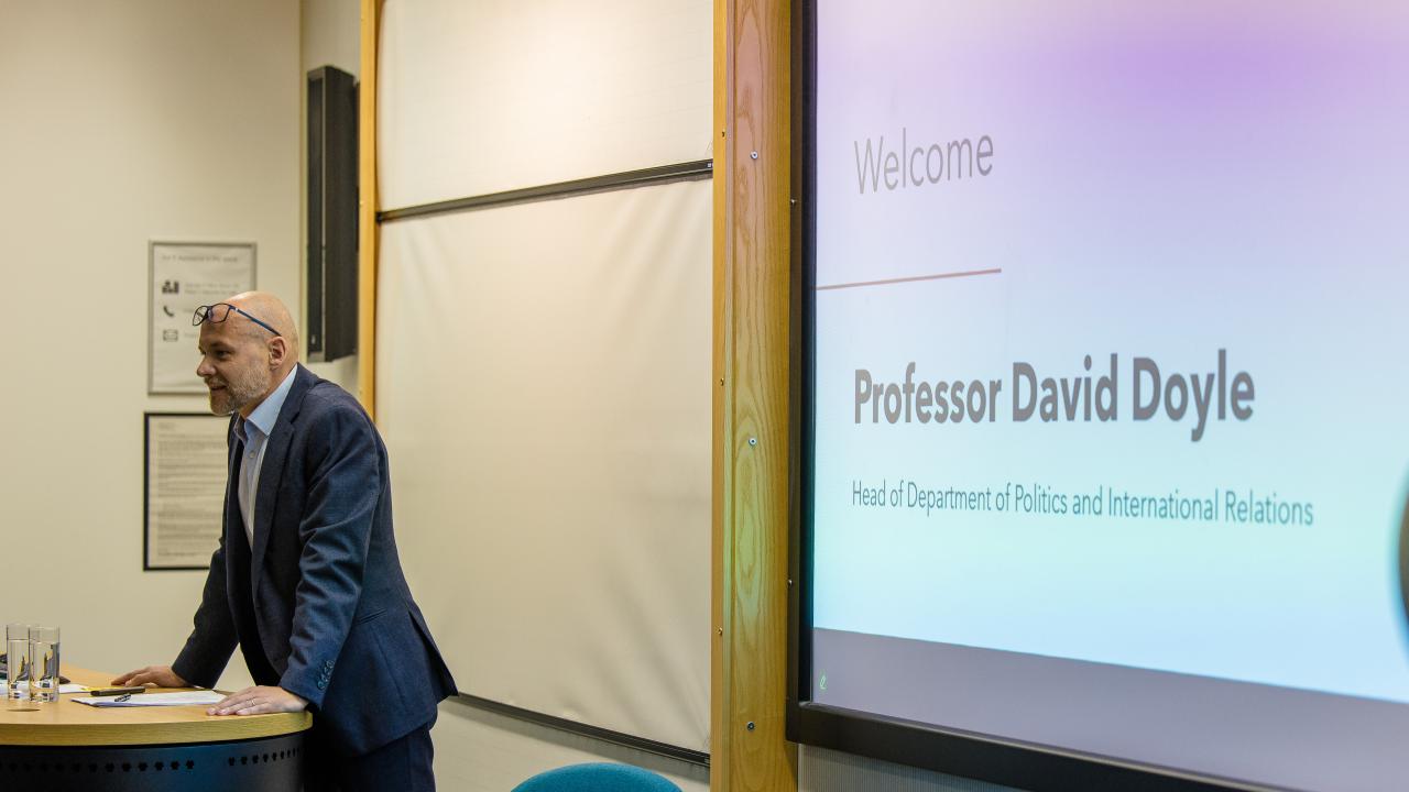 a man in front of a projector screen