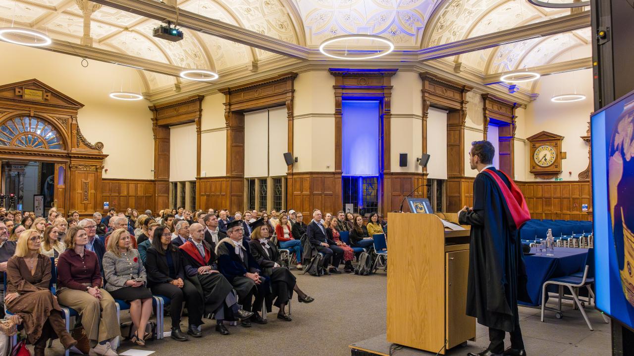 image of a man at a lectern in front of an audience