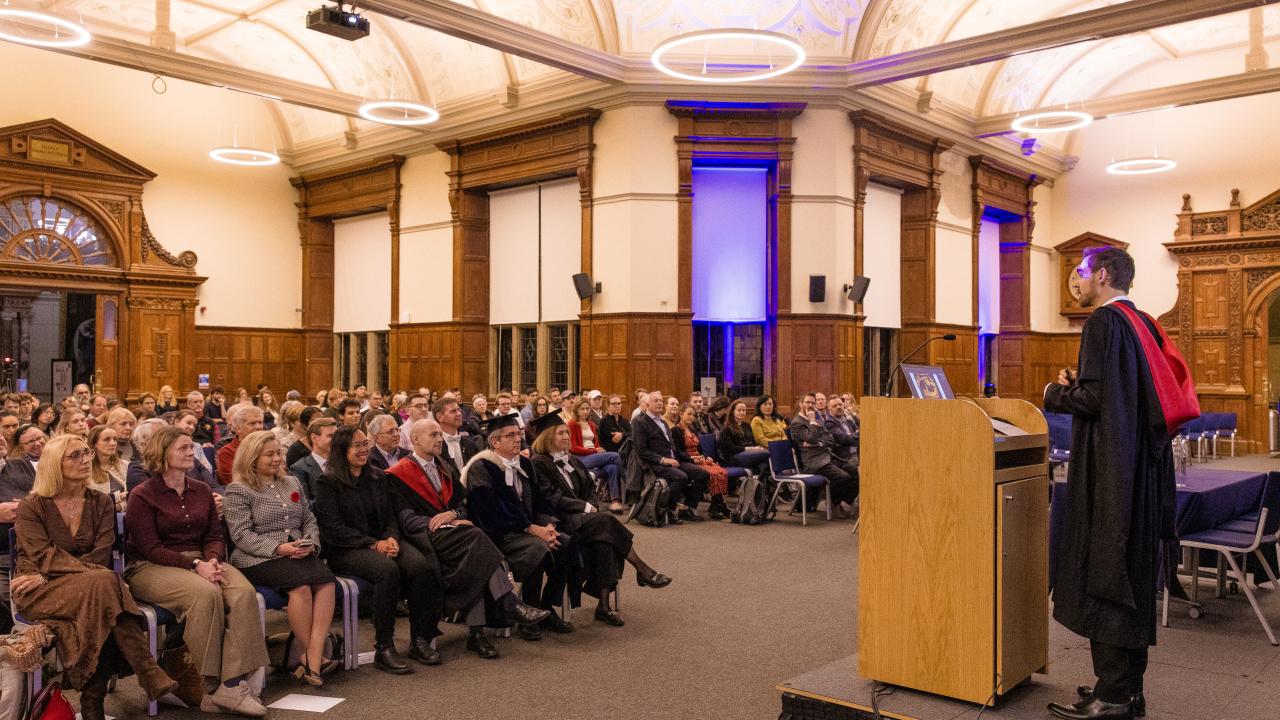 image of a man at a lectern in front of an audience