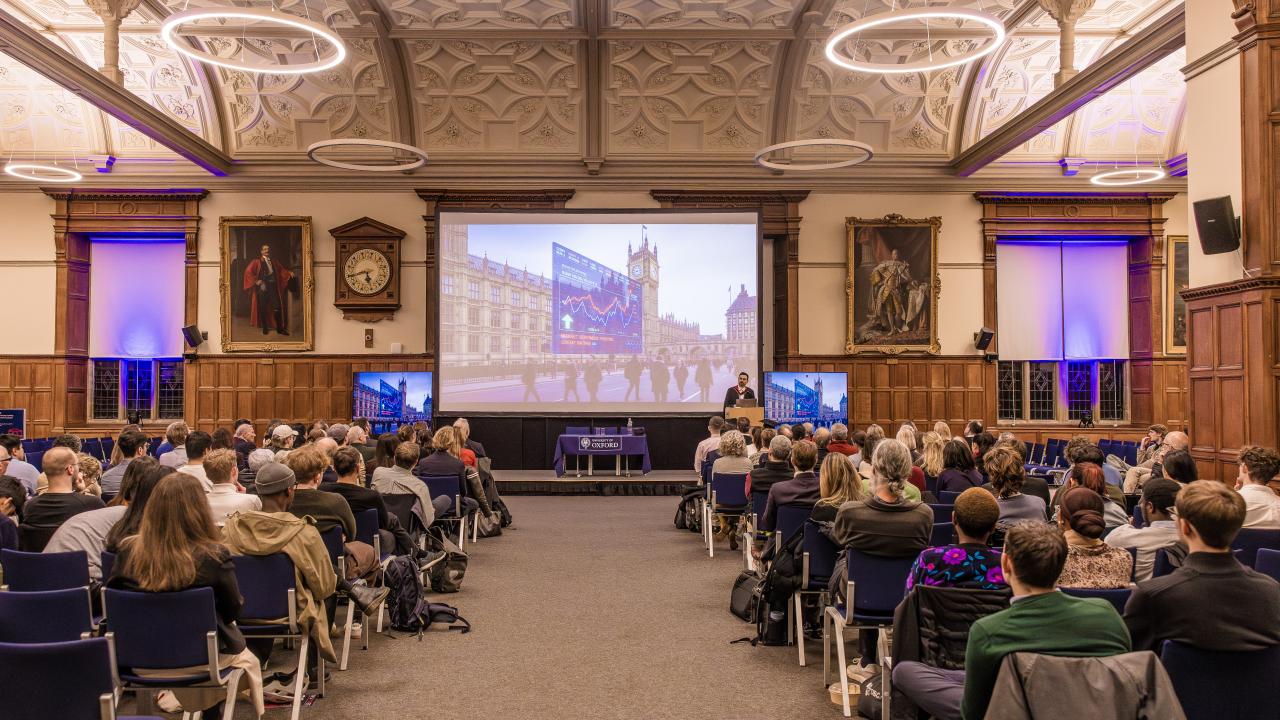 image from behind of an audience listening to a lecture