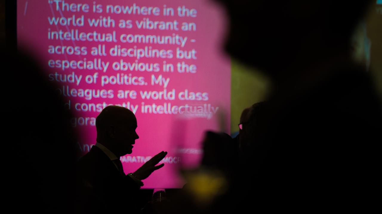 silhouetted image of a man stood in front of a projector screen