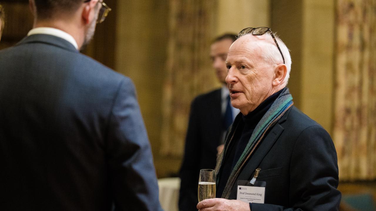 image of a man with his back to the camera talking to another man