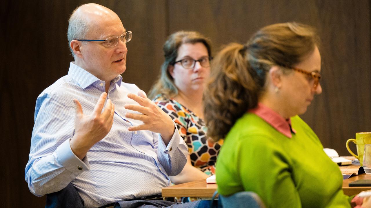 side image of three people sat in a room