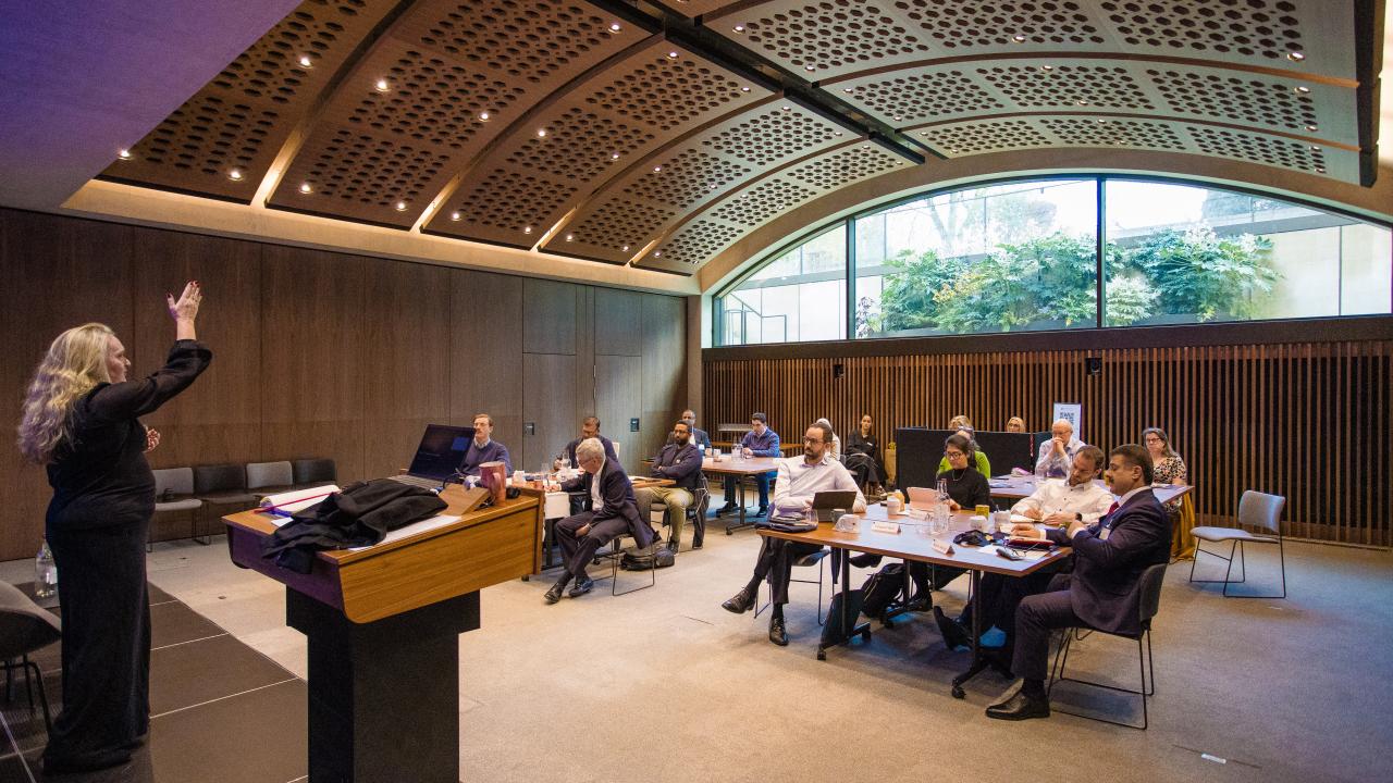 image of an audience in a room with a vaulted ceiling listening to a lecture
