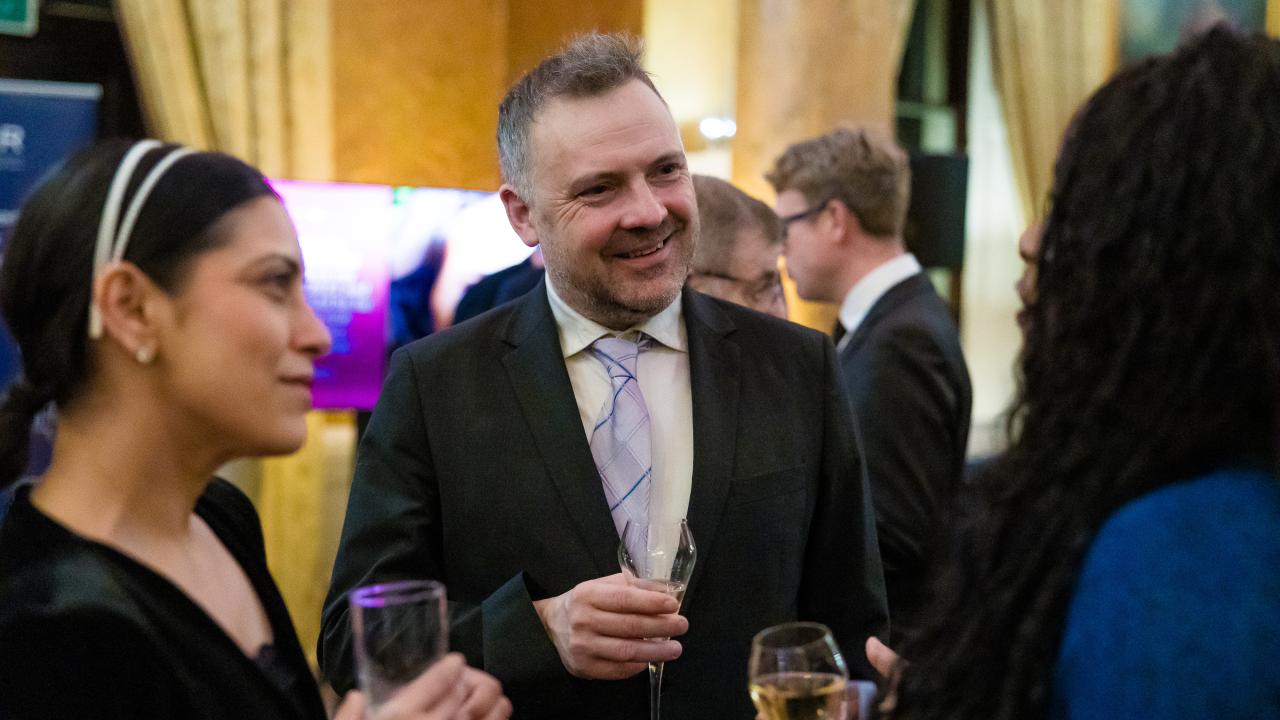 image of two people talking to someone with their back to the camera