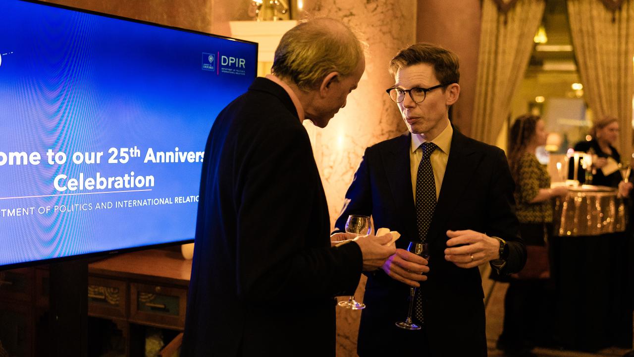 image of two people talking in front of a projector screen