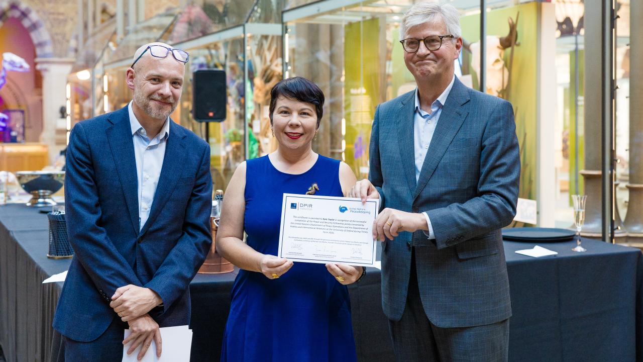 image of two men presenting a certificate to a woman