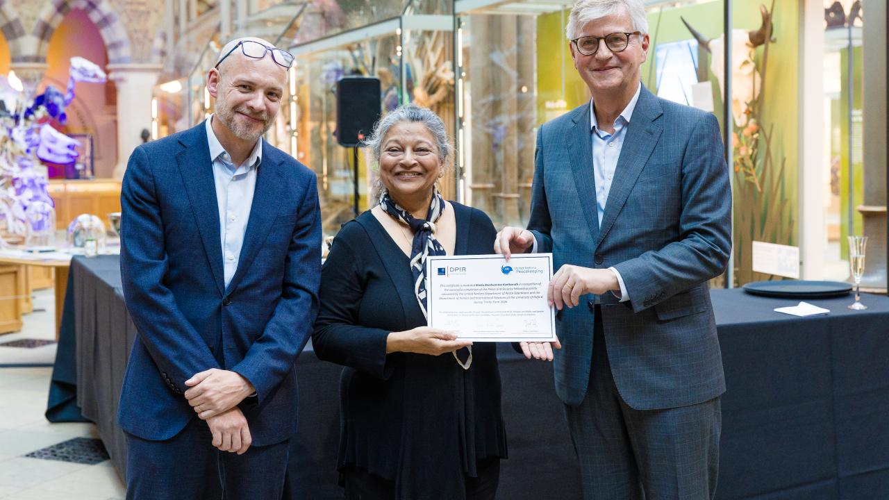 image of two men presenting a certificate to a woman