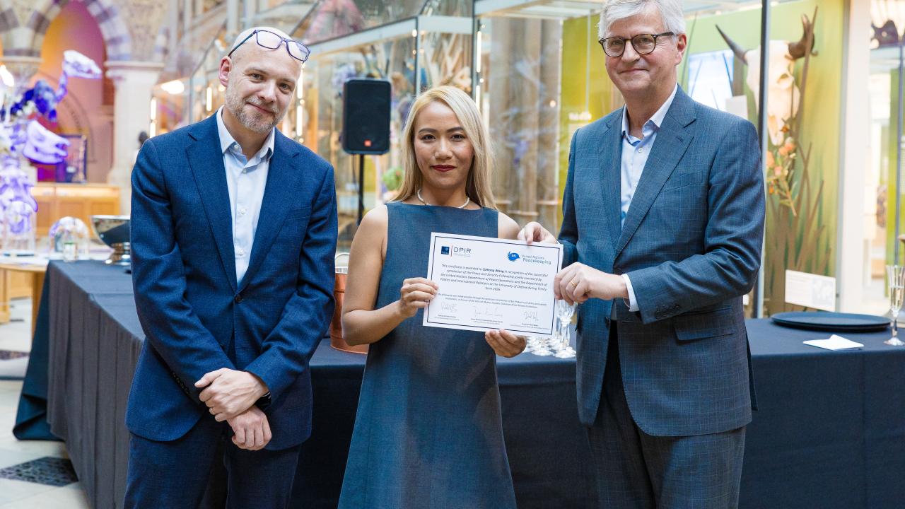 image of two men presenting a certificate to a woman