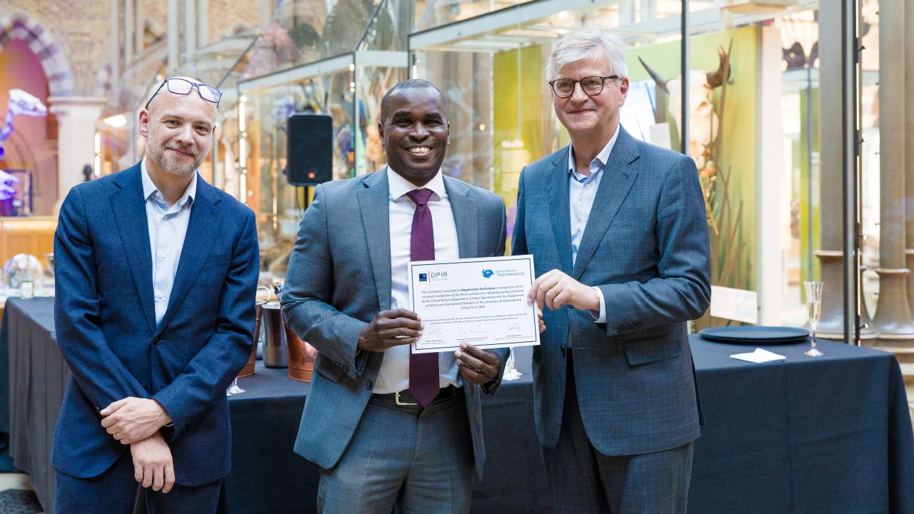 image of two men presenting a certificate to another man