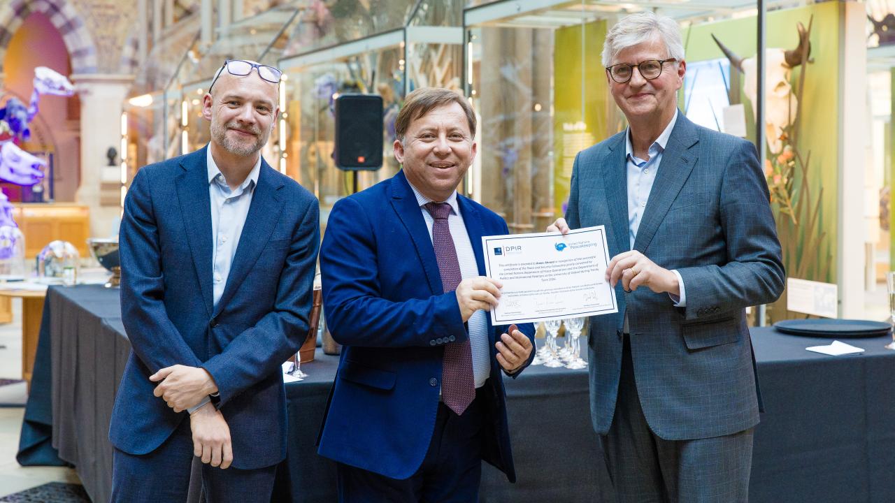 image of two men presenting a certificate to another man