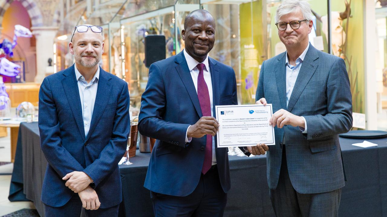 image of two men presenting a certificate to another man
