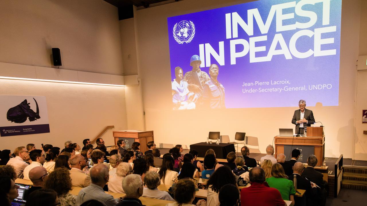 image taken from the back of a room where a lecture is taking place