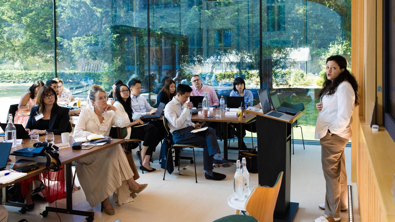 room full of people listening to a lecture being given by a woman