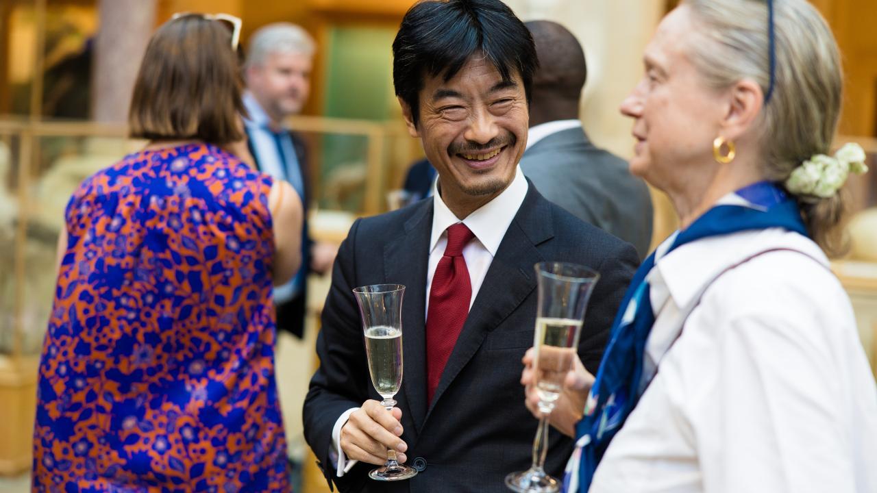image of a man and woman stood talking with drinks glasses in their hands
