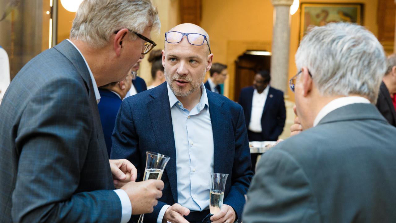 image of three men stood talking