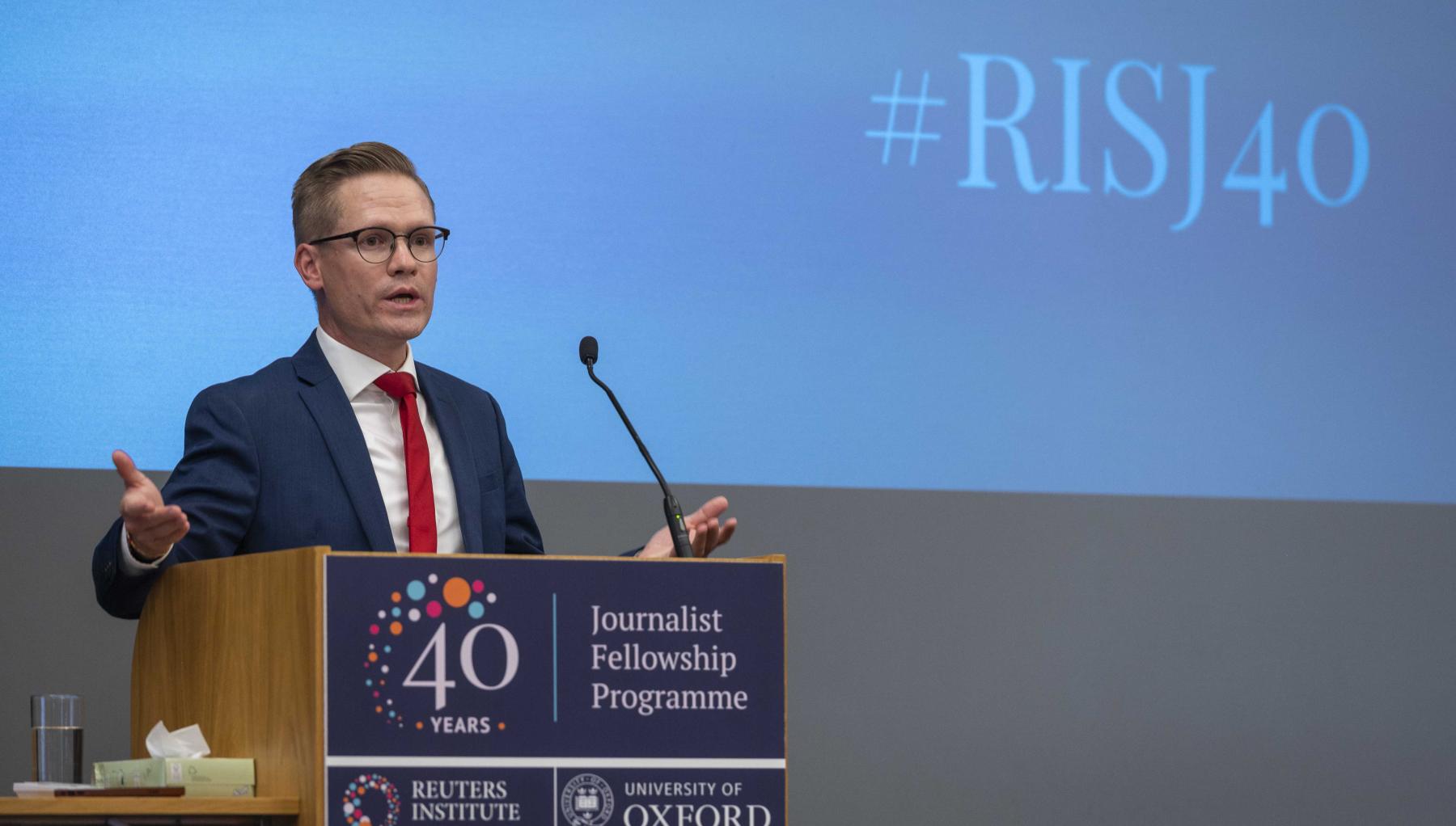 Image of Rasmus speaking on stage at a conference