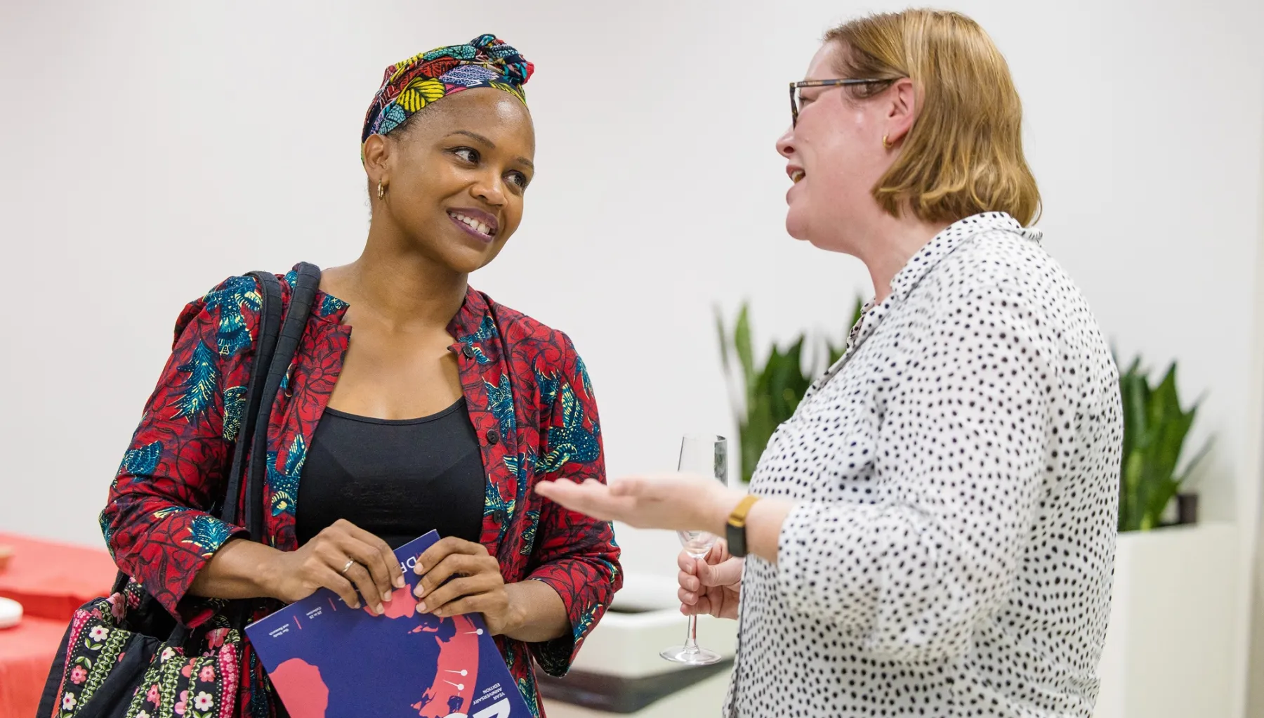 Two women talking at 25th anniversary event