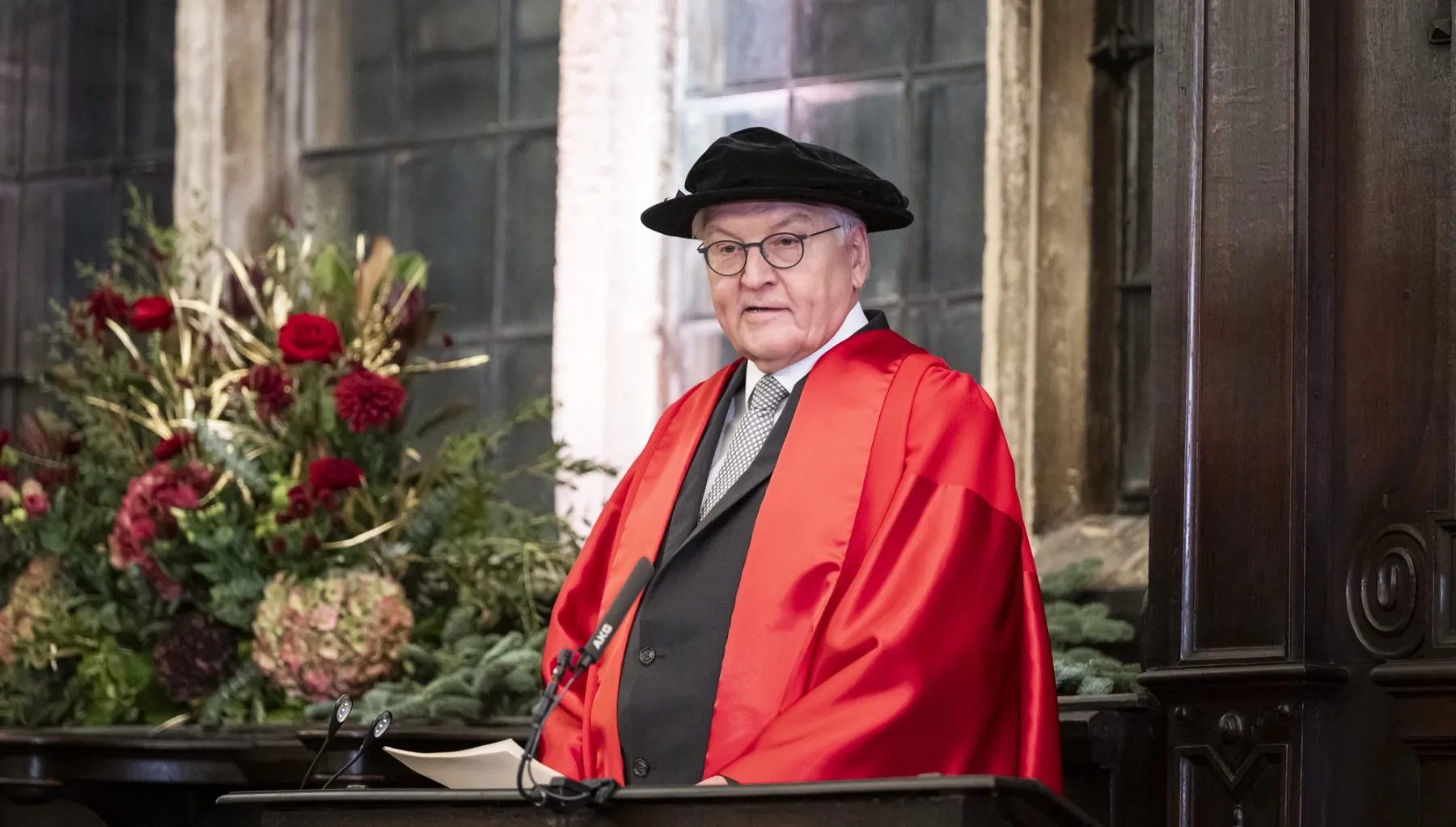image of a man in academic ceremonial garb looking at the camera