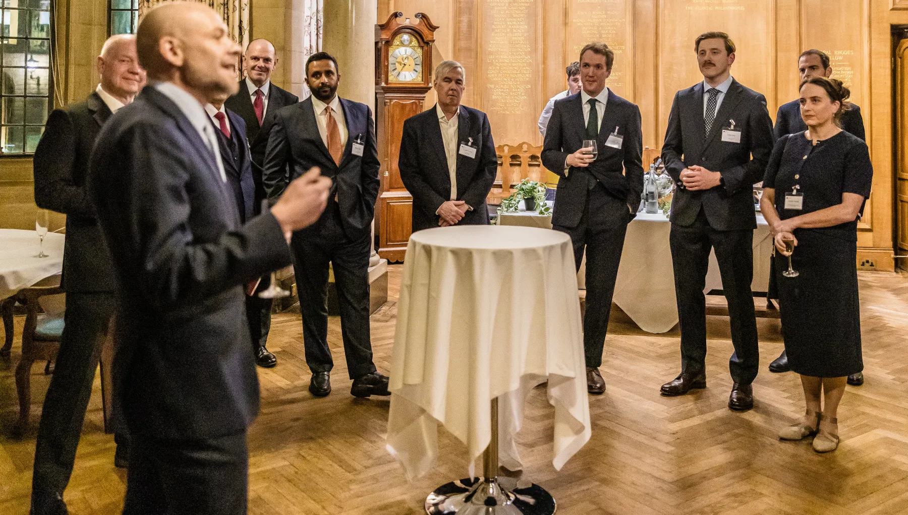 image of a group of people stood in a room with a round table in the centre