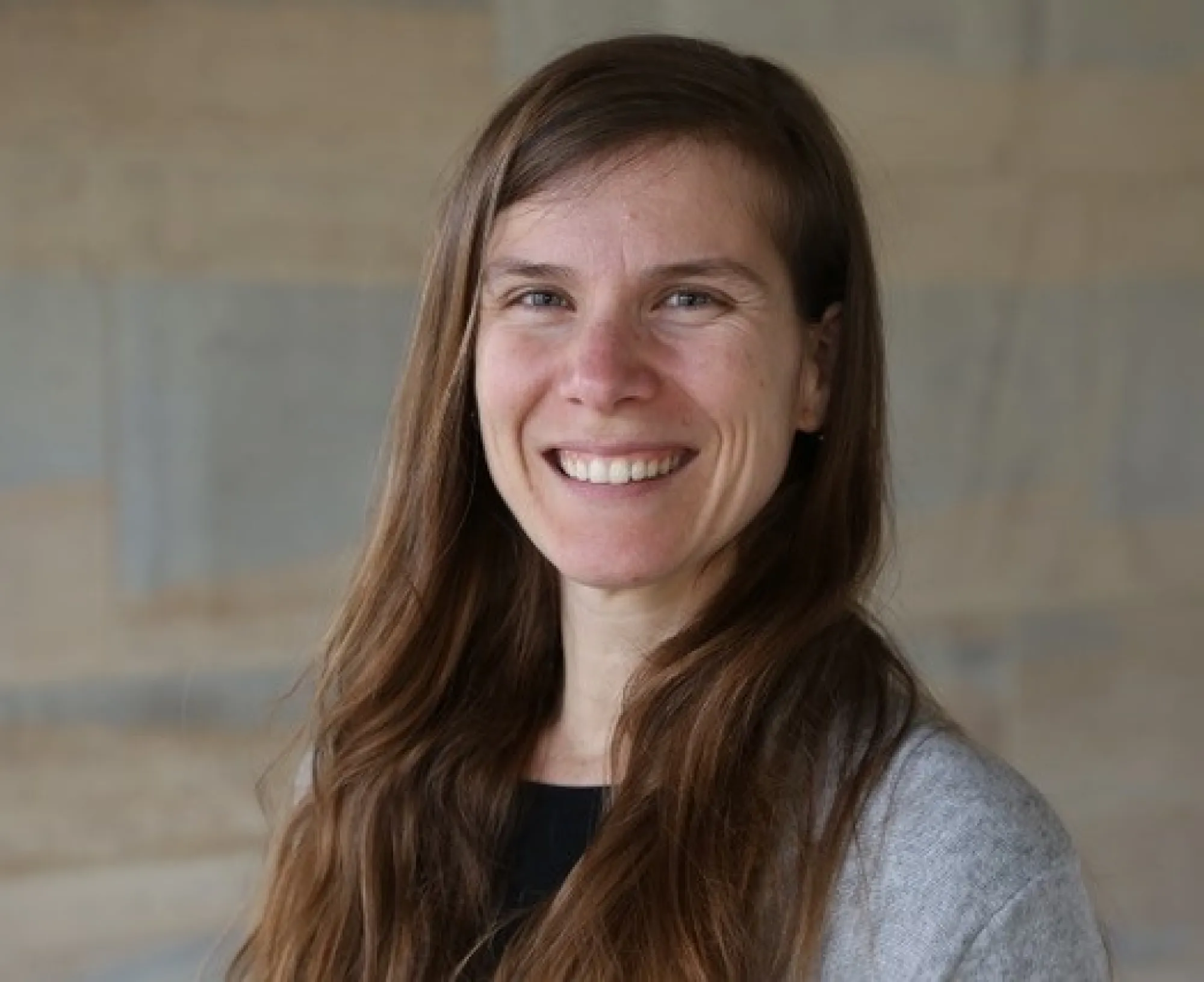 A person with long hair smiling