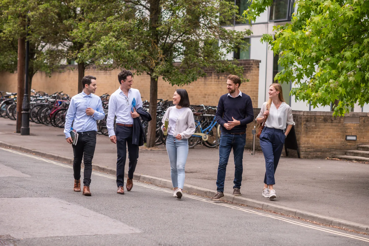 image of a group of five people walking down a road with a building in the background