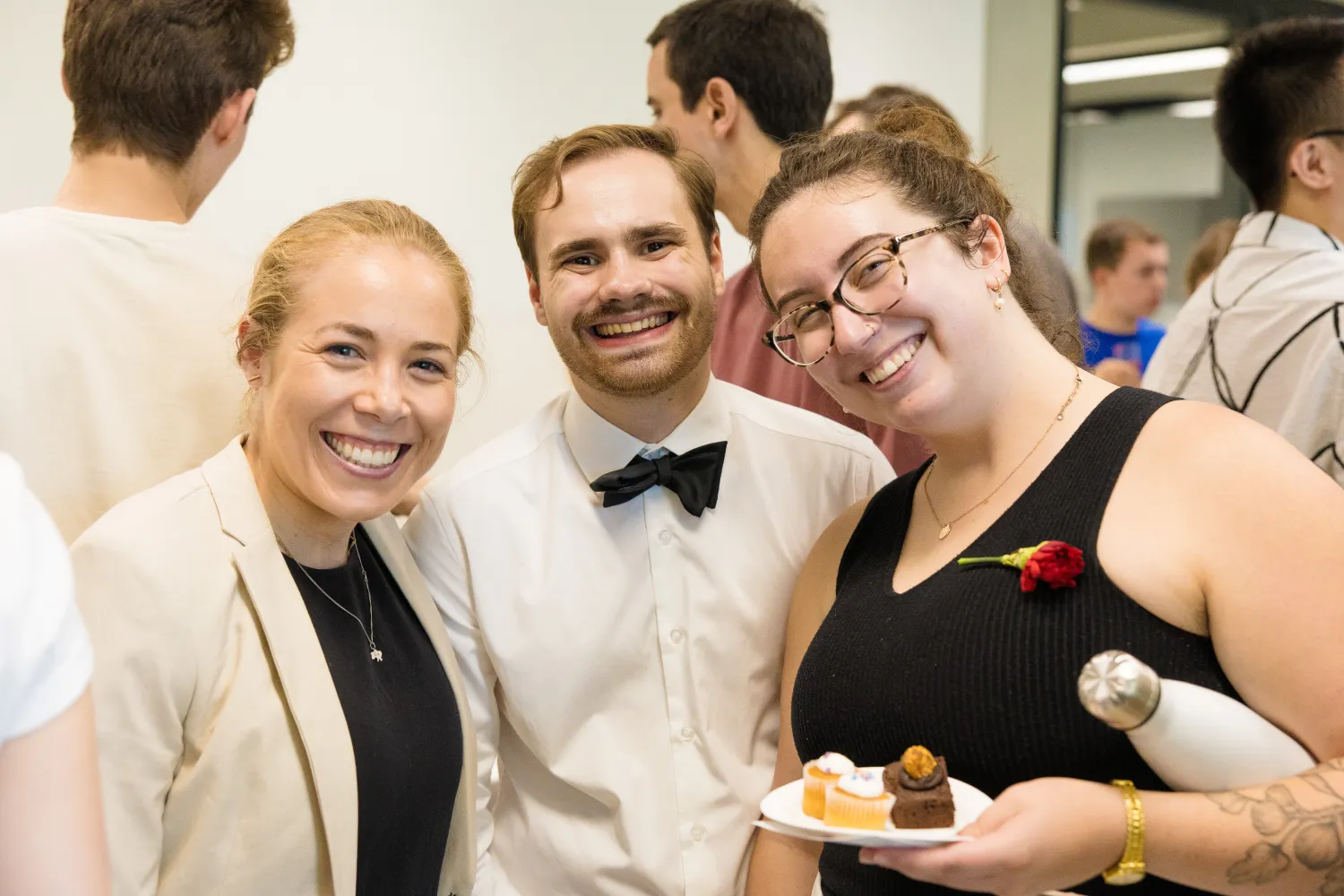 Image of three people stood together smiling at the camera