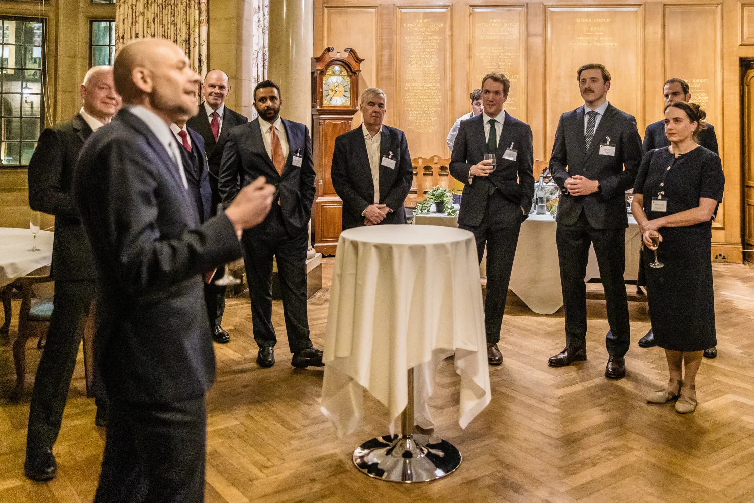 image of a group of people stood in a room with a round table in the centre