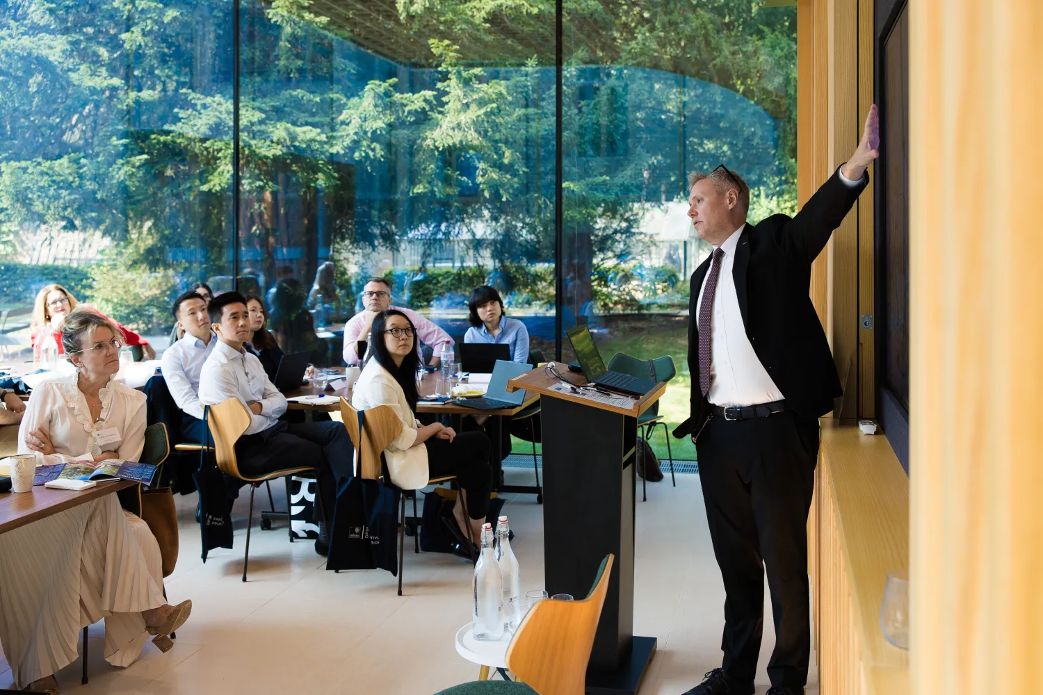 image of a man pointing to a board in front of an audience in a lecture room
