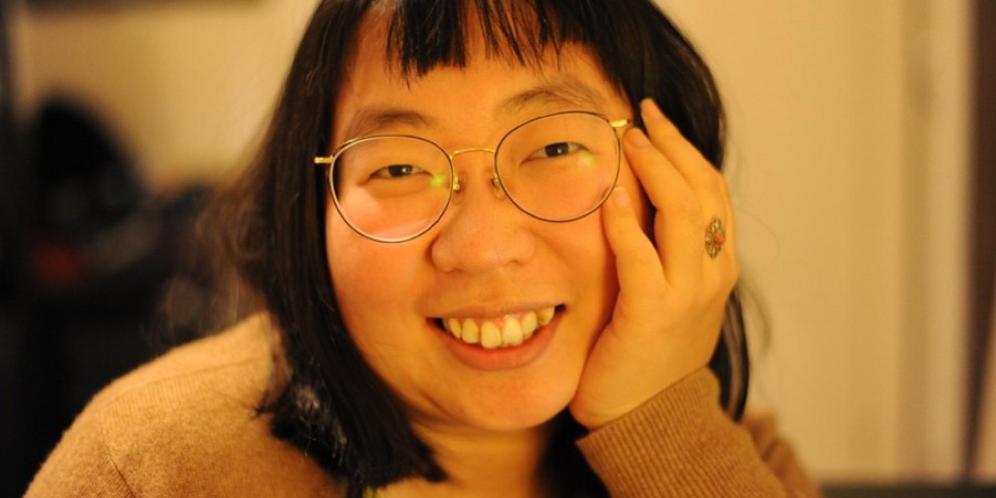 Image of a woman wearing glasses smiling at the camera
