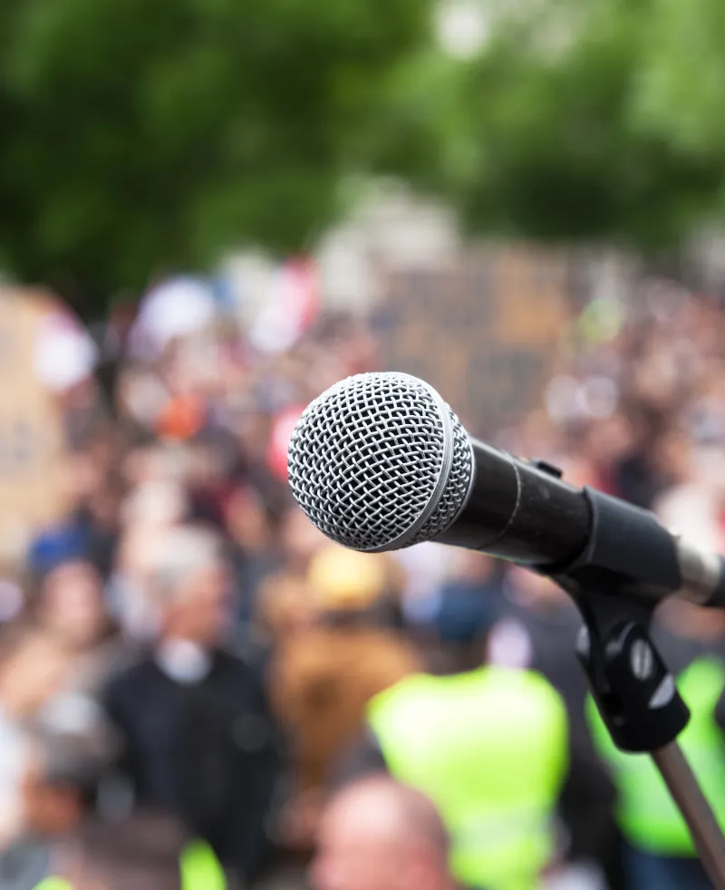 image of a microphone in front of a crowd of people