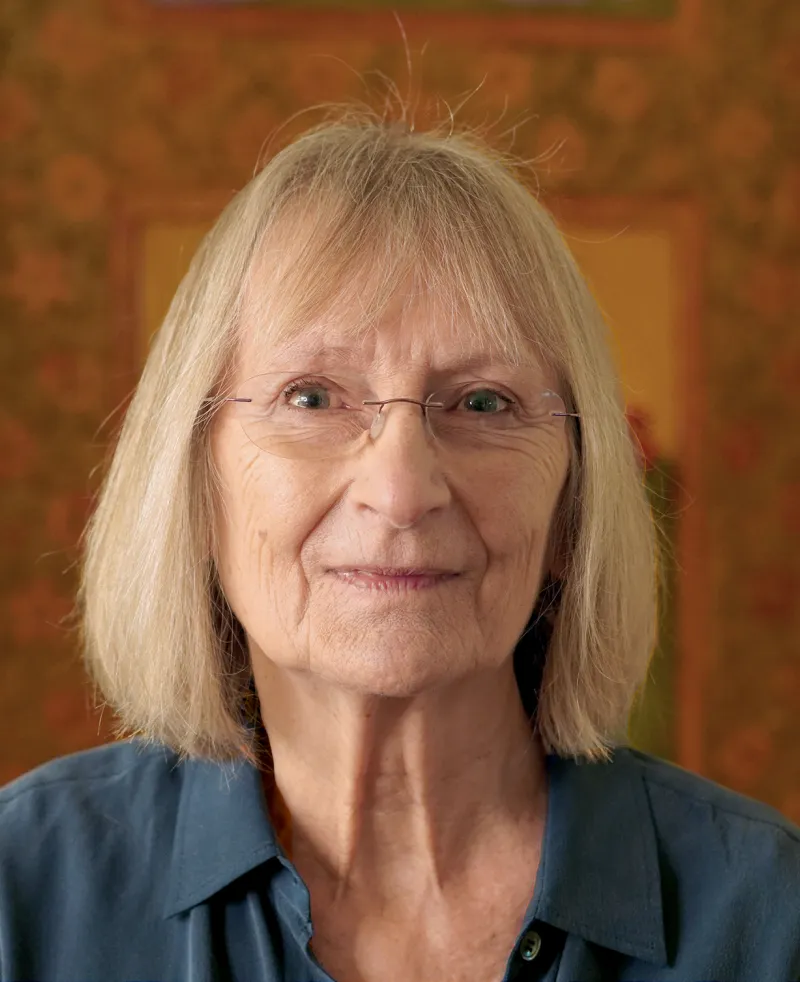 Image of a woman wearing glasses smiling at the camera