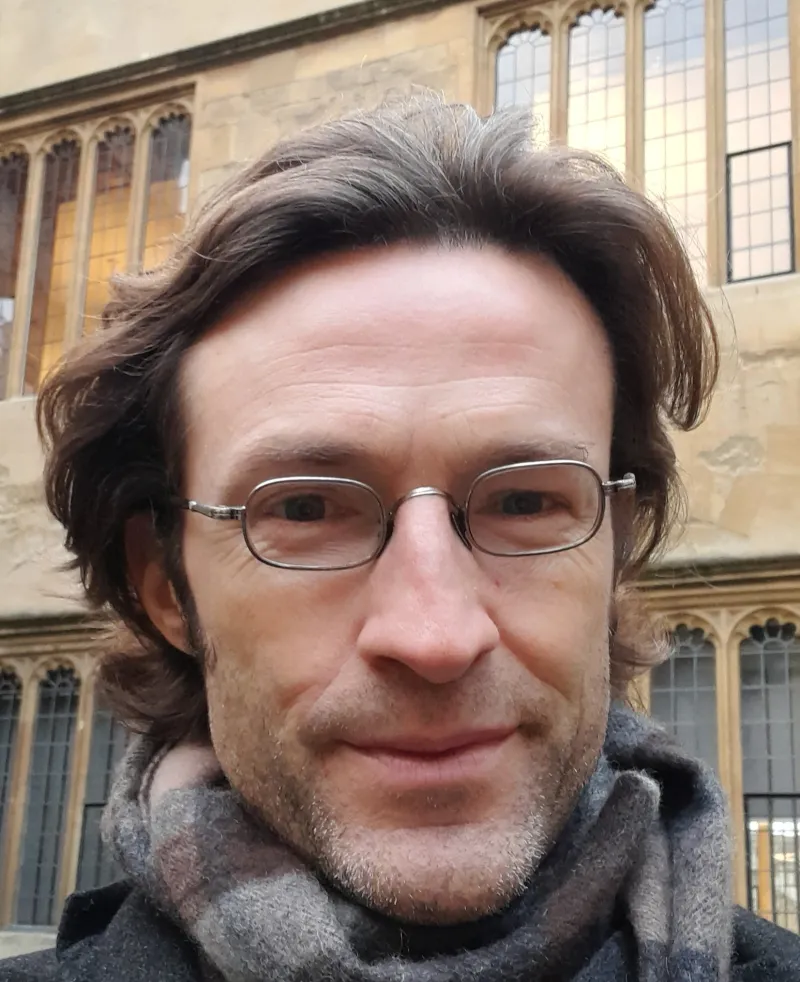 image of a man wearing glasses smiling at the camera