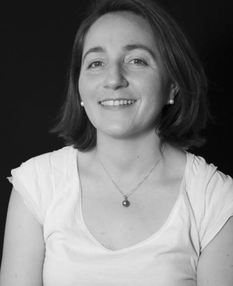 Image of a woman wearing a white top smiling at the camera